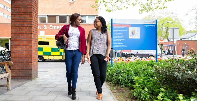 Two people walking outside A&E