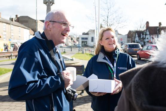 To Healthwatch volunteers speaking to someone at an outdoor event